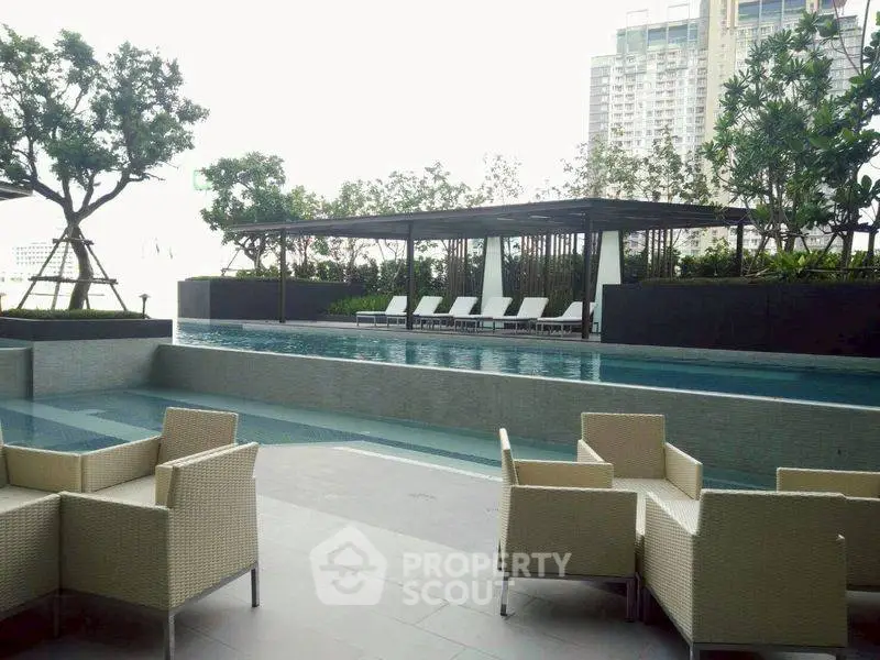 Luxurious poolside area with modern seating and skyline view, perfect for relaxation and entertainment.