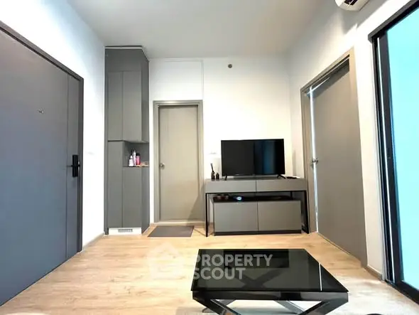 Modern living room with sleek furniture and wooden flooring in a stylish apartment.