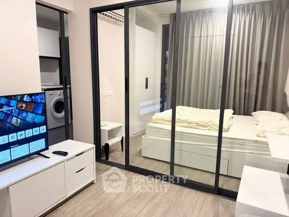 Modern studio apartment with glass partition and sleek furnishings