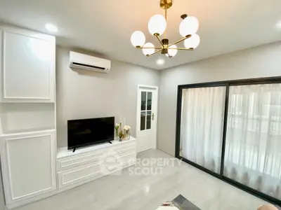 Modern living room with elegant chandelier and sleek TV setup