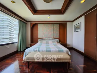 Luxurious bedroom with elegant wood paneling and large window offering city views.
