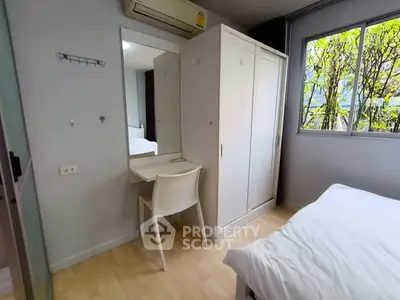 Cozy bedroom with natural light, featuring a wardrobe, desk, and bed for a comfortable living space.