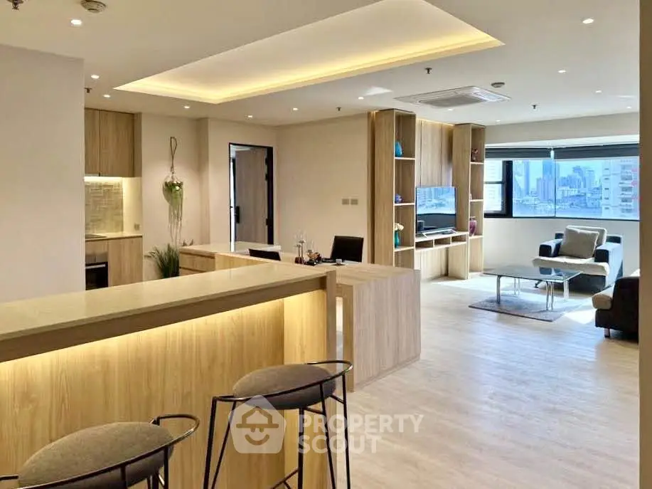 Spacious modern living room with open layout and city view, featuring stylish furniture and elegant lighting.