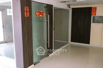 Modern interior space with glass doors and wooden paneling, ideal for office or retail setup.