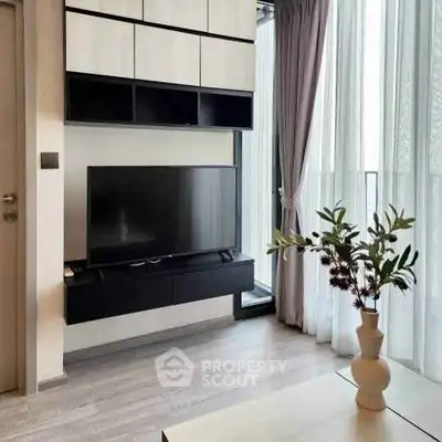 Modern living room with sleek TV setup and elegant decor in a bright apartment.