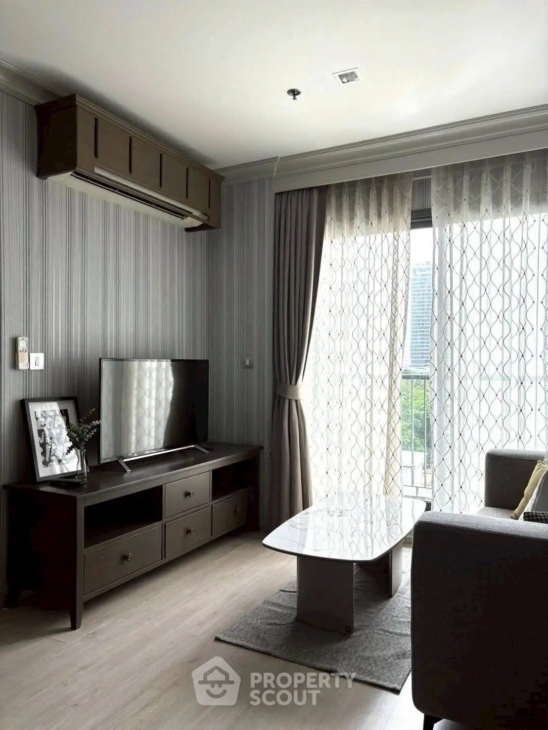 Modern living room with stylish decor, large window, and sleek furniture in a contemporary apartment.