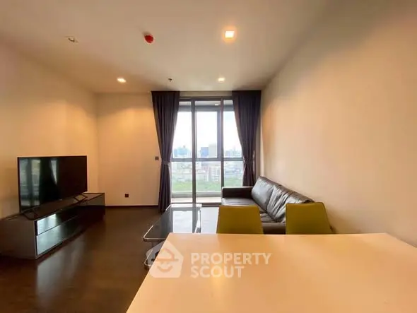 Spacious modern living room with city view, sleek furniture, and large windows.