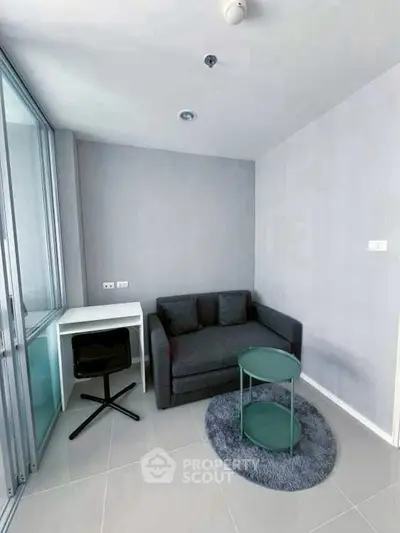 Modern compact living room with sleek sofa and stylish round table in a cozy apartment.