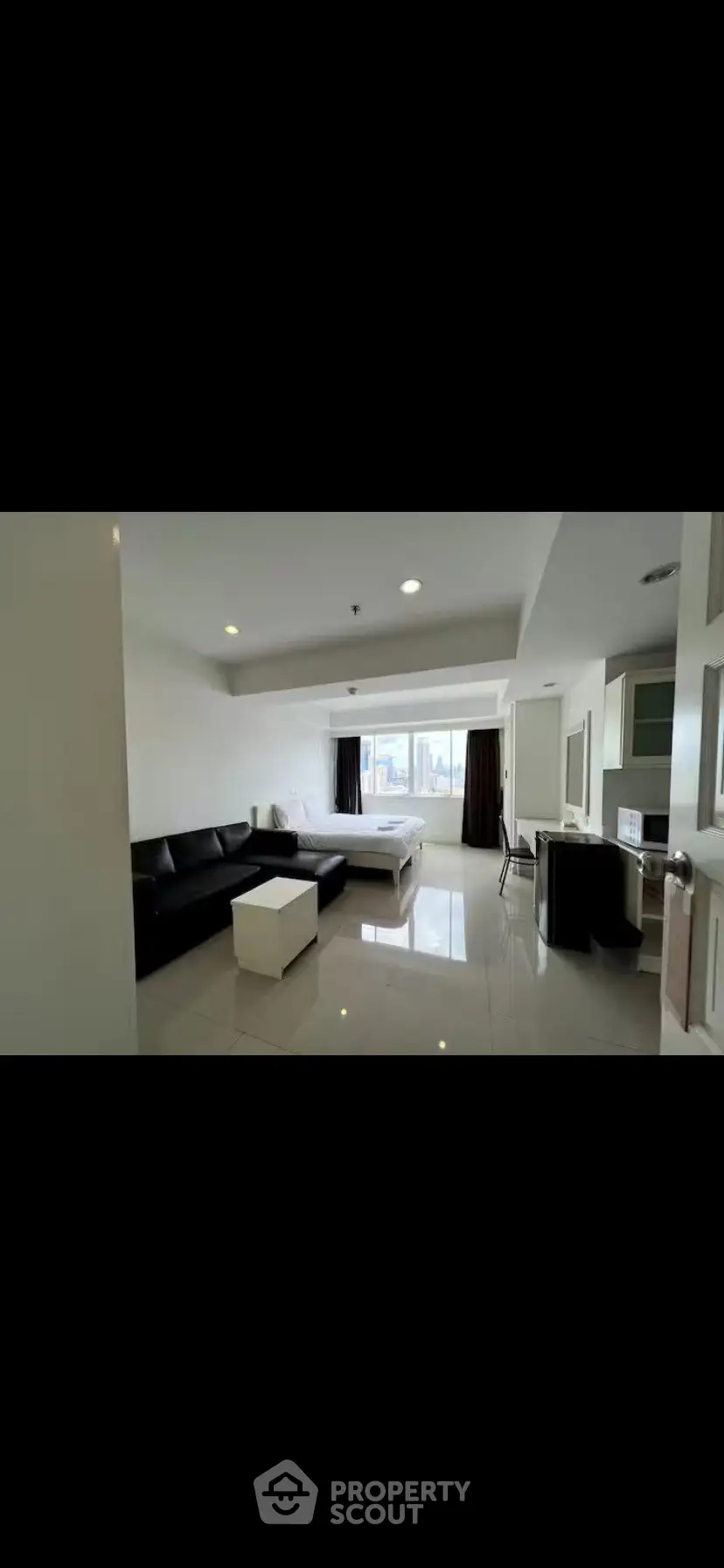 Spacious modern studio apartment with sleek furnishings and city view.