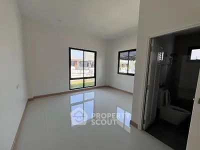 Spacious room with large windows and glossy tile flooring, perfect for natural light lovers.