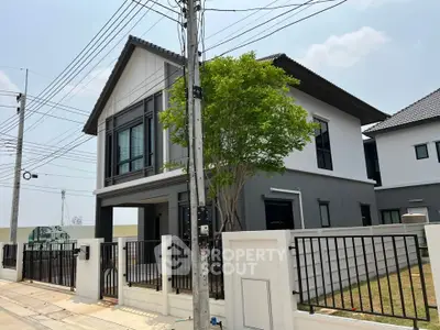 Modern two-story house with sleek design and spacious yard in suburban neighborhood.