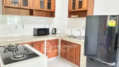Charming kitchen with wooden cabinets, modern appliances, and sleek countertops.