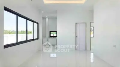 Spacious modern interior with large windows and sleek white design, perfect for natural light lovers.