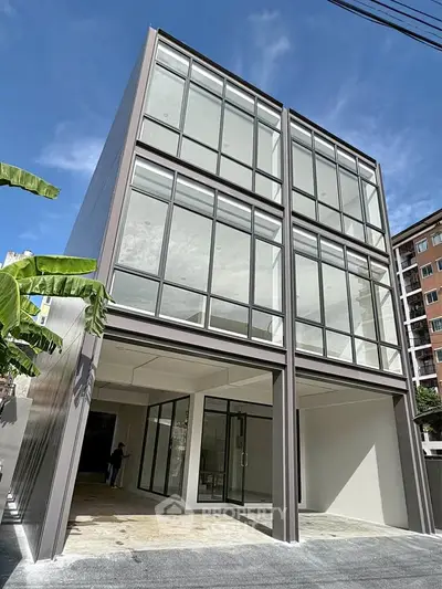 Modern three-story building with large glass windows and sleek design