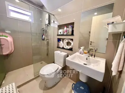 Modern bathroom with glass shower and sleek fixtures in contemporary home.