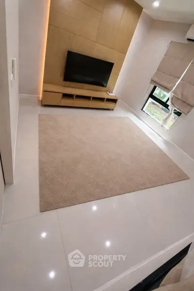Modern living room with sleek TV setup and cozy carpet flooring