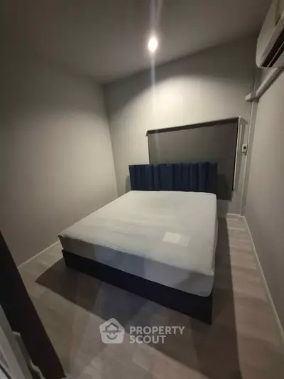 Cozy bedroom with modern bed and air conditioning in minimalist design.