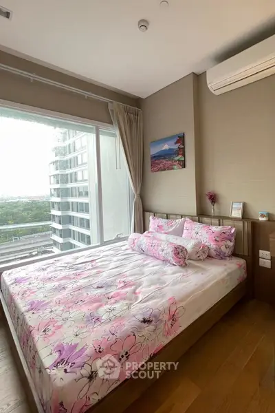 Bright bedroom with large window and floral bedding in modern apartment