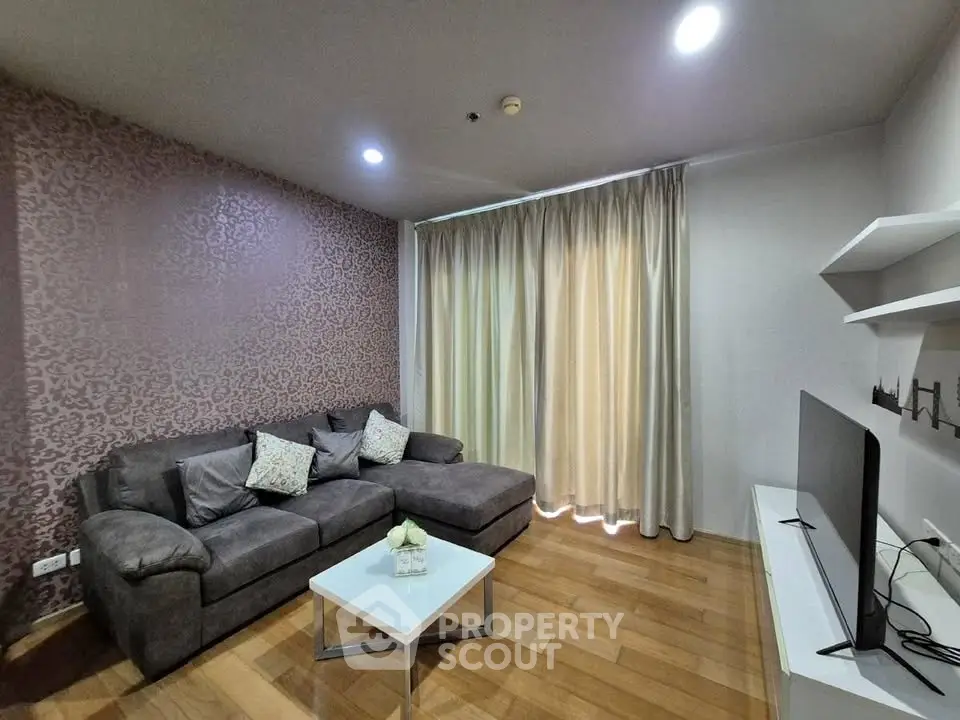 Cozy living room with modern decor, featuring a plush sectional sofa and sleek TV setup.