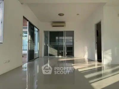 Spacious modern living room with large windows and glossy tiled floor