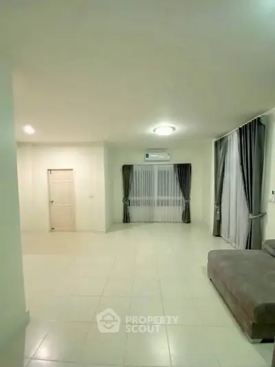 Spacious living room with modern sofa and large windows for natural light.