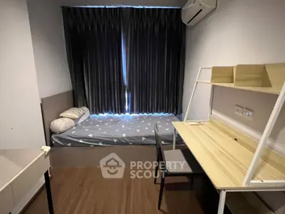 Cozy bedroom with modern desk and comfortable bed, perfect for students or professionals.