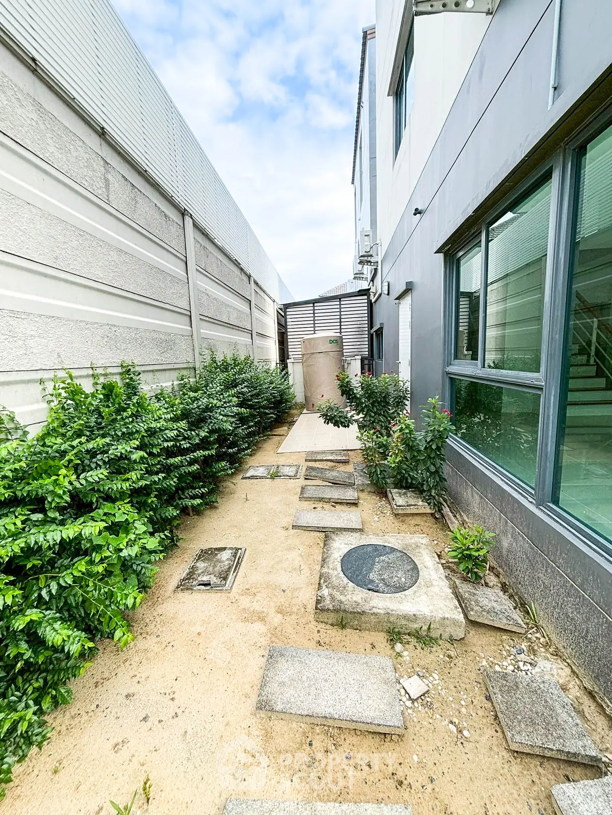 Modern building exterior with landscaped walkway and greenery