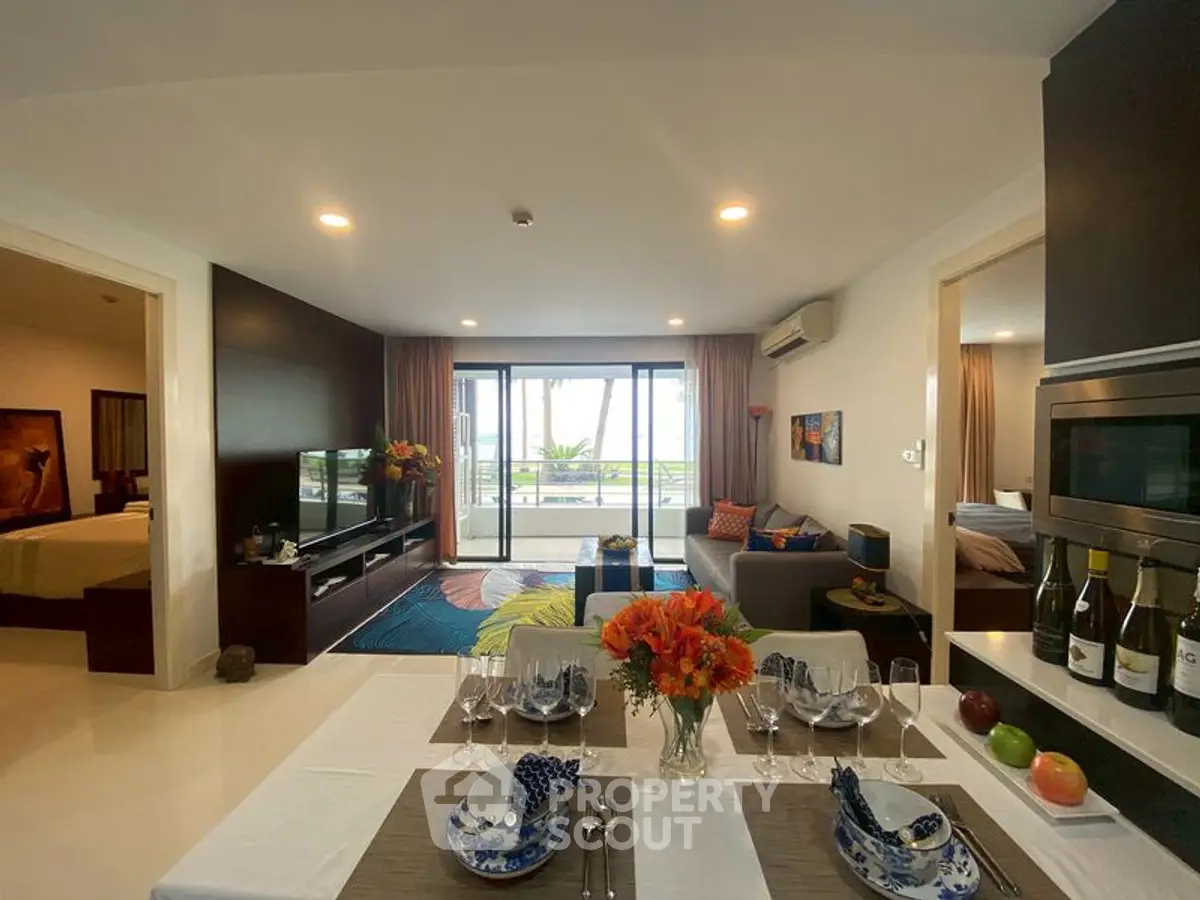 Luxurious open-plan living room with elegant dining area and stunning balcony view.
