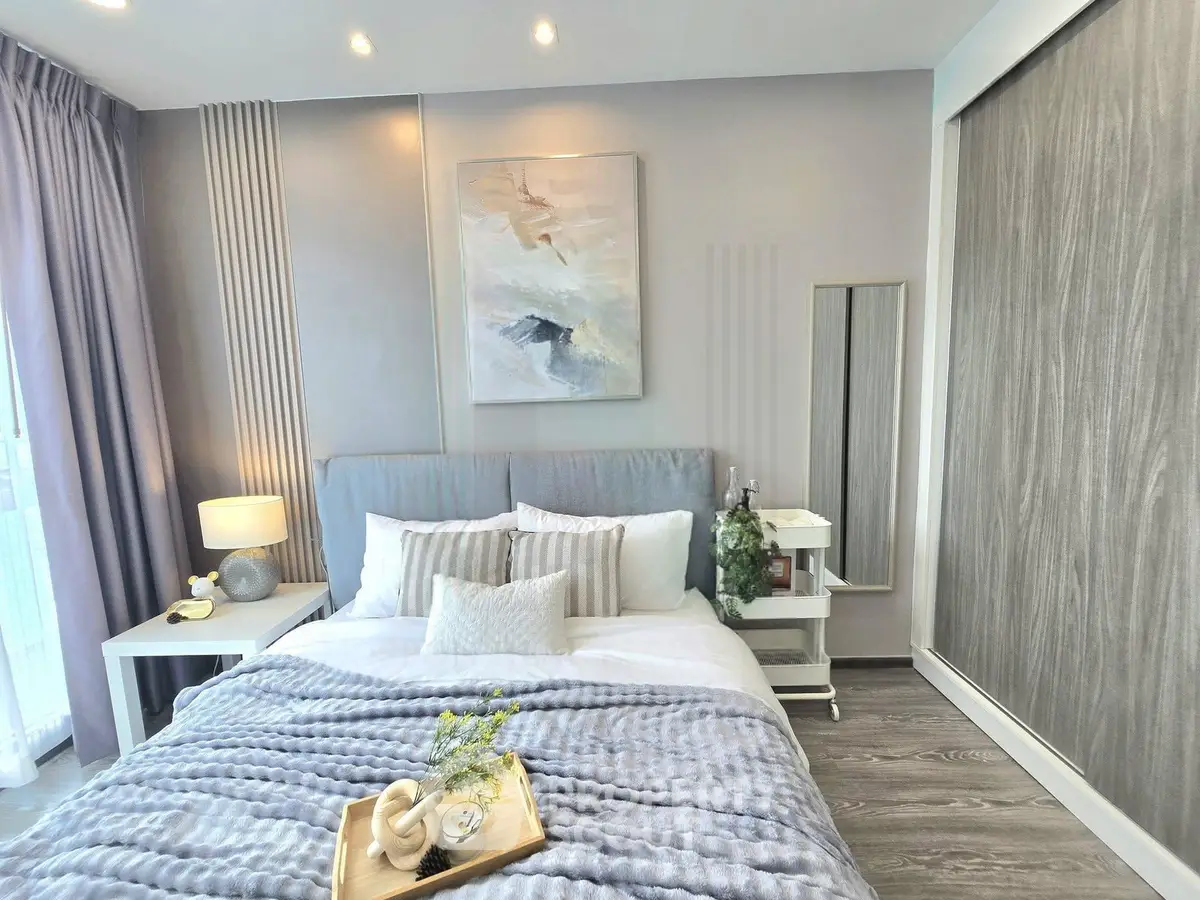Modern bedroom with stylish decor and cozy ambiance, featuring elegant bedding and contemporary artwork.