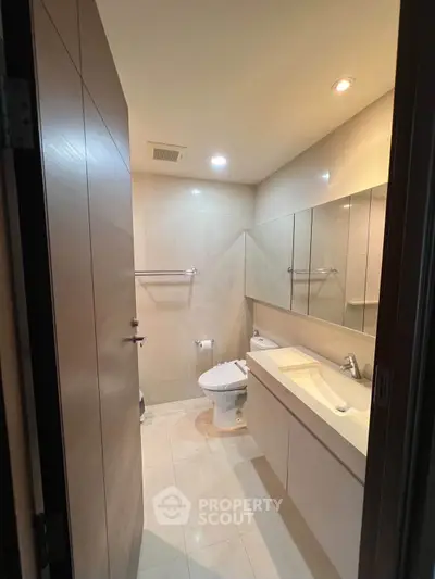 Modern bathroom with sleek fixtures and ample lighting in a contemporary apartment.