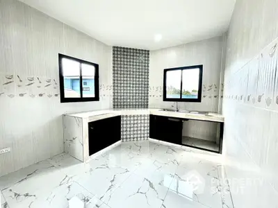 Modern kitchen with sleek black cabinets and marble tile flooring