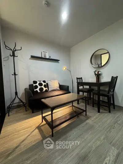 Cozy living room with modern decor, featuring a stylish sofa, elegant dining set, and chic lighting.