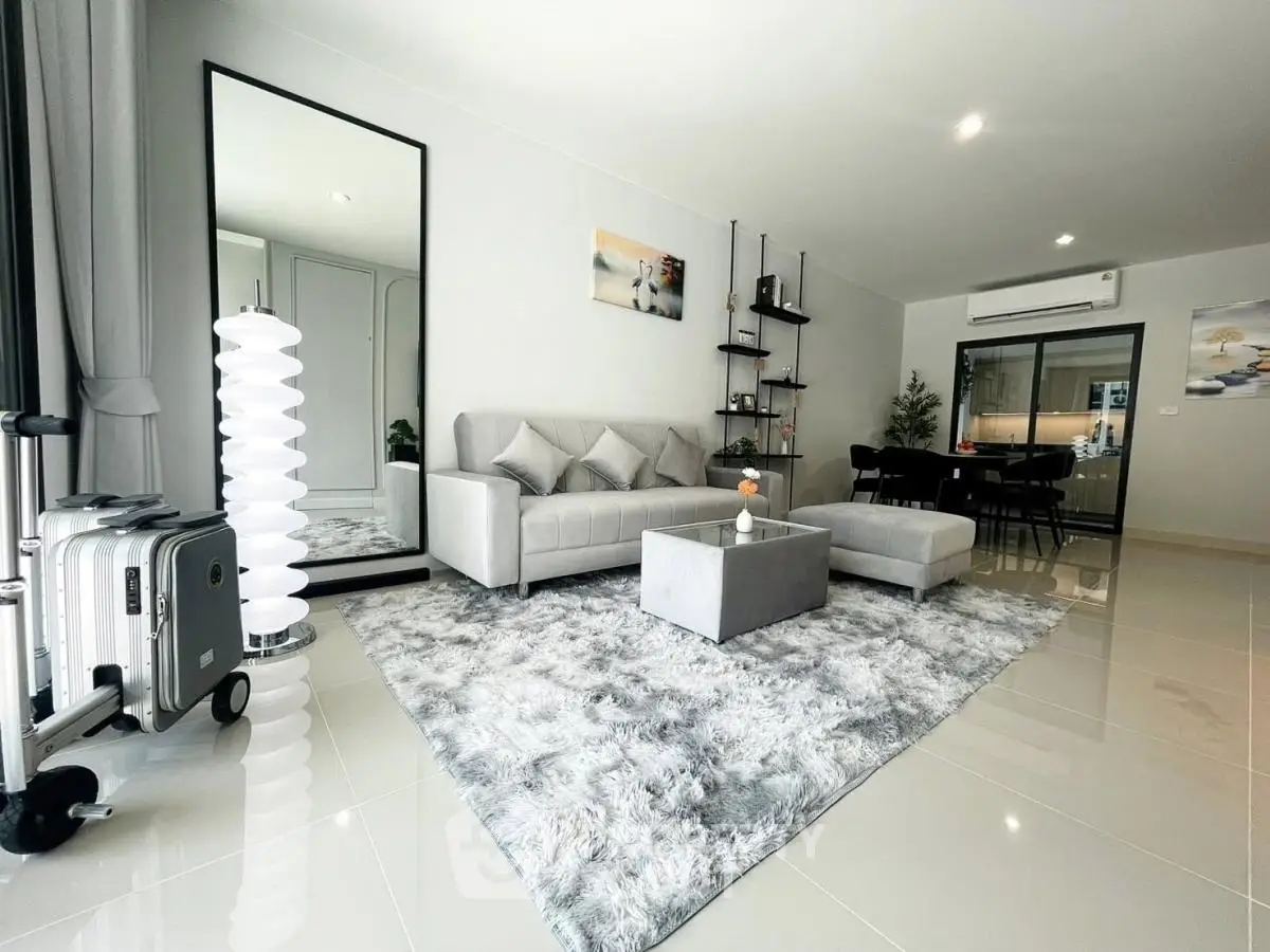 Modern living room with elegant decor and plush rug in a stylish apartment.