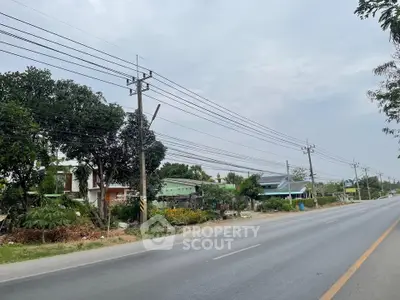 Scenic roadside view with residential houses and lush greenery