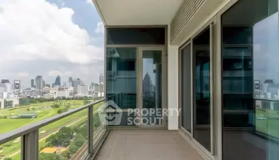Spacious balcony with stunning city skyline view in modern high-rise apartment.