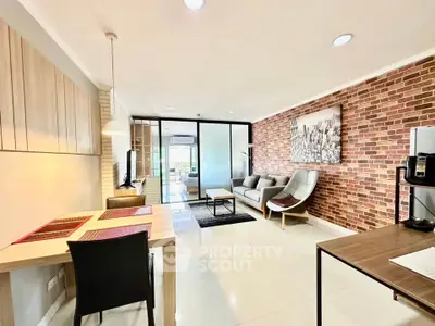 Modern living room with brick accent wall and stylish furniture in open layout apartment.