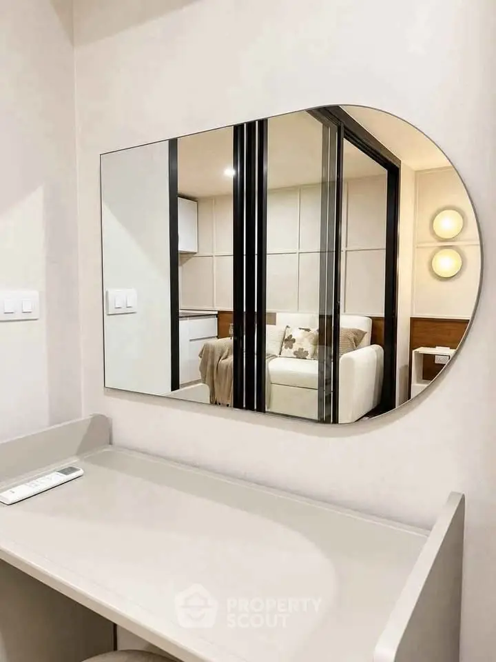 Modern interior with stylish mirror reflecting cozy living room and elegant decor.