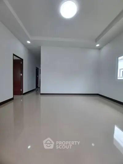 Spacious empty room with glossy tiled floor and modern ceiling lights