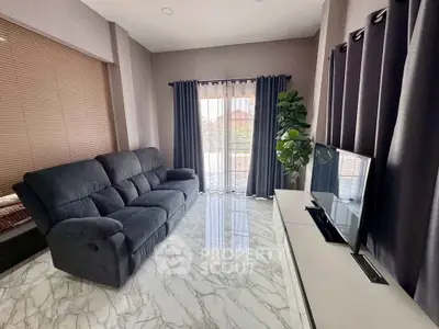 Modern living room with sleek marble flooring, plush sofa, and large TV, perfect for relaxation and entertainment.