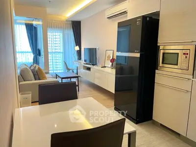 Modern open-plan living room and kitchen with sleek appliances and stylish decor.