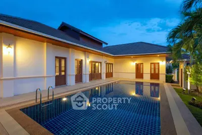 Luxurious villa with private pool and elegant exterior lighting at dusk.