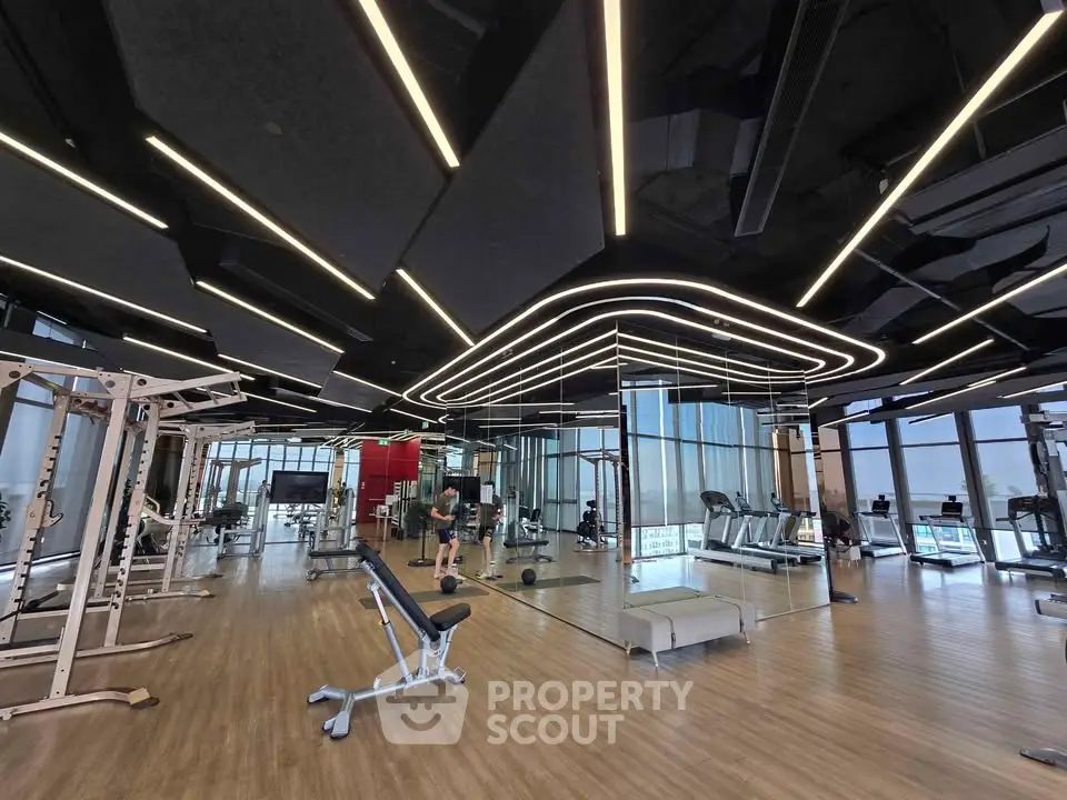 Luxurious modern gym with state-of-the-art equipment and stylish lighting in a high-end residential building.