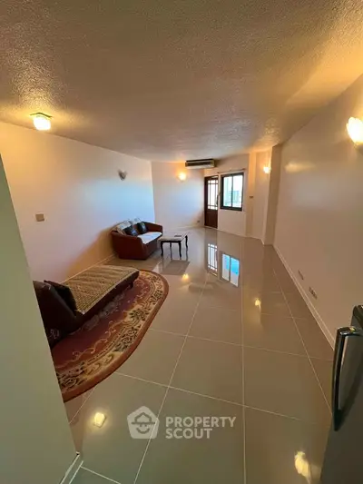 Spacious living room with glossy tiled floors and cozy seating area.