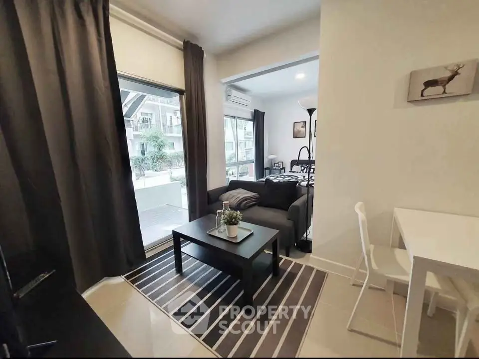 Modern living room with stylish decor and large windows in a cozy apartment.