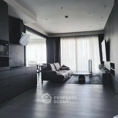 Modern living room with sleek black furniture and large windows for natural light.