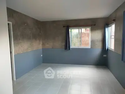 Spacious empty room with large windows and modern design, perfect for customization.