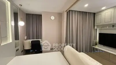 Modern bedroom with stylish decor and large TV, featuring elegant curtains and cozy lighting.