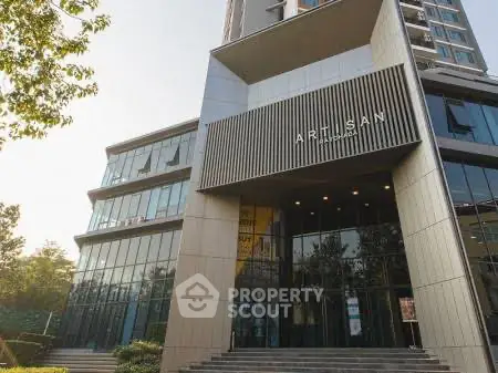 Modern building entrance with sleek design and glass facade, showcasing contemporary architecture.