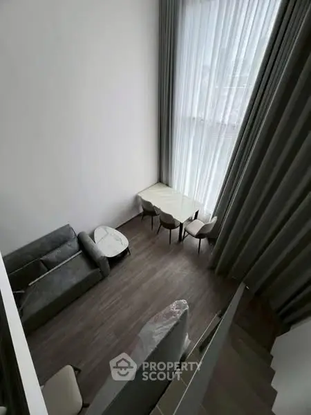 Modern loft-style living room with high ceilings and large windows