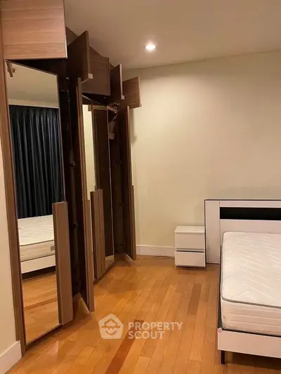 Spacious bedroom with wooden flooring and modern wardrobe design